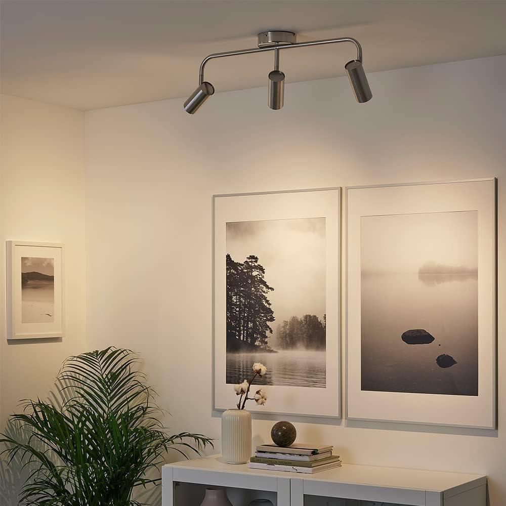 Modern ceiling track lighting with three adjustable LED spotlights in a minimalist living room.